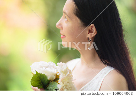 Asian woman in white dress with flower bouquet 109064008
