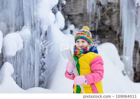 Children play with icicle in snow. Kids winter fun 109064011