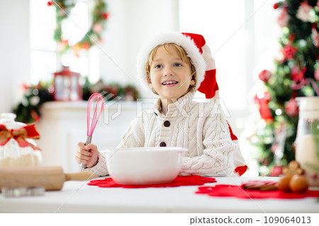 Family baking Christmas cookies. Kids Xmas fun. 109064013