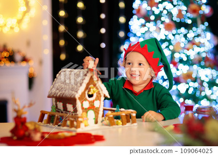 Kids baking gingerbread house. Christmas at home. 109064025