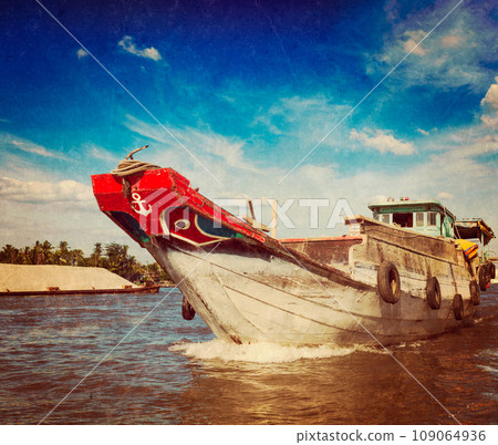 Vintage retro hipster style travel image of boat on Mekong river delta, Vietnam with grunge texture overlaid 109064936