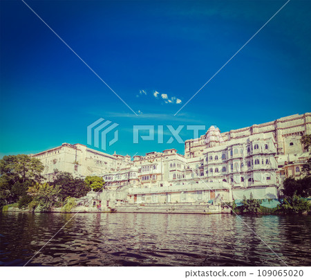 Vintage retro hipster style travel image of India luxury tourism concept background - Udaipur City Palace from Lake Pichola. Udaipur, Rajasthan, India 109065020