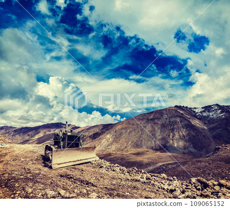 Vintage retro effect filtered hipster style travel image of Bulldozer on road in Himalayas. Ladakh, Jammu and Kashmir, India Vintage retro effect filtered hipster style travel image of Bulldozer on road in Himalayas. Ladakh, Jammu and Kashmir, India 109065152