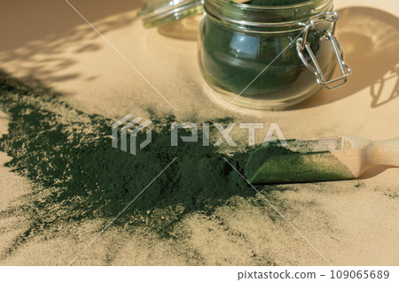 Organic blue-green algae spirulina powder food in glass jar with wooden spoon. Health benefits of spirulina chlorella. Dietary supplement superfood Organic blue-green algae spirulina powder food in glass jar with wooden spoon. Health benefits of spirulina chlorella. Dietary supplement superfood 109065689