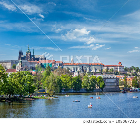 Panorama view of Vltava river and Gradchany (Prague Castle) and St. Vitus Cathedral and Charles bridge an people in paddle boats in the Prague, Czech Republic Panorama view of Vltava river and Gradchany (Prague Castle) and St. Vitus Cathedral and Charles bridge an people in paddle boats in the Prague, Czech Republic 109067736