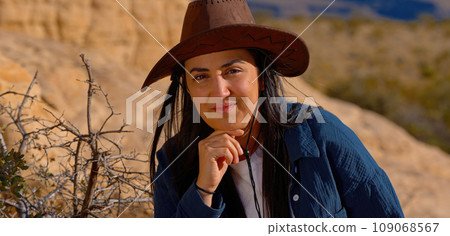 Portrait shot of a young cowgirl wearing a cowboy hat posing for the camera 109068567