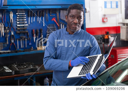 African mechanic man using a laptop computer checking car in workshop African mechanic man using a laptop computer checking car in workshop 109069206