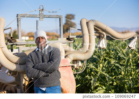 Man standing at fumigator on artichoke plantation 109069247