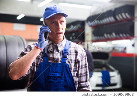 Car mechanic calls on smartphone to client 109069968