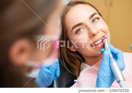 Woman patient sitting in a medical chair during teeth grinding procedure. Teeth care concept  109070289