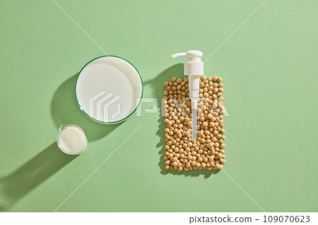 Soybeans are arranged in the shape of a pump bottle. A beaker and petri dish filled with soybean milk. Soybean (Glycine max) also aids in removing dry, flaky skin 109070623