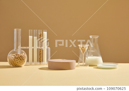 Some types of laboratory glassware containing soybean seeds and milk arranged with a brown podium. Pedestal or platform for beauty products presentation 109070625