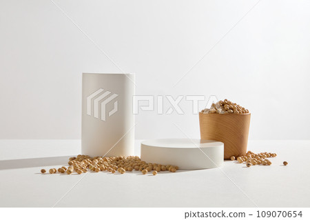 Cylinder and round podiums arranged with a wooden bowl of soybeans. Geometric shapes podium for product display. Soybeans can be added to skin care products Cylinder and round podiums arranged with a wooden bowl of soybeans. Geometric shapes podium for product display. Soybeans can be added to skin care products 109070654