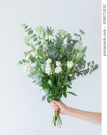 Hand holding green and white herbal bouquet 109072832