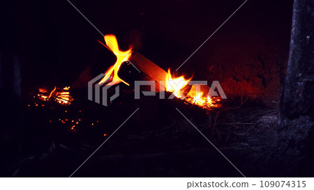 A fire is burning in an old stove in the wall. A fire is burning in an old stove in the wall. 109074315