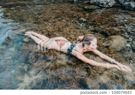 Woman travel sea. Happy tourist enjoy taking picture outdoors for memories. Woman traveler swim in the sea bay with mountains, sharing travel adventure journey Woman travel sea. Happy tourist enjoy taking picture outdoors for memories. Woman traveler swim in the sea bay with mountains, sharing travel adventure journey 109074683