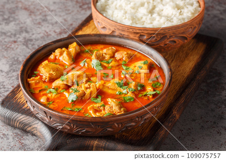 Chicken lahori is a traditional Pakistani chicken curry hailing from the city of Lahore served with rice closeup on the wooden board. Horizontal Chicken lahori is a traditional Pakistani chicken curry hailing from the city of Lahore served with rice closeup on the wooden board. Horizontal 109075757