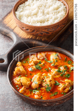 Chicken Lahori is a South Asian curry which originated in Lahore, Pakistan served with rice closeup on the wooden board. Vertical 109075766