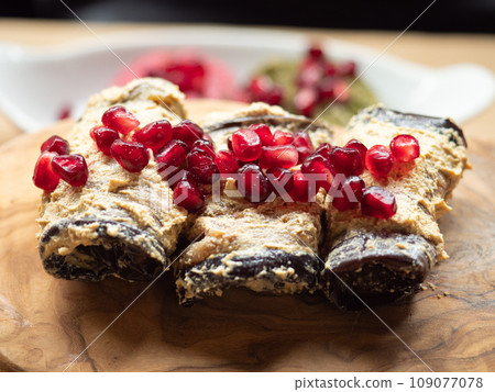 A delicious vegan plate: Aubergine rolls with humus and a topping of pomegranat seeds A delicious vegan plate: Aubergine rolls with humus and a topping of pomegranat seeds 109077078