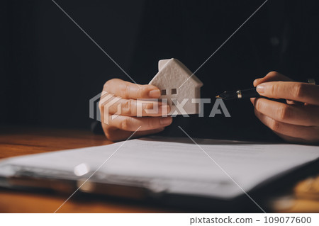 Real estate agent and customer signing contract to buy house, insurance or loan real estate.rent a house,get insurance or loan real estate or property. 109077600