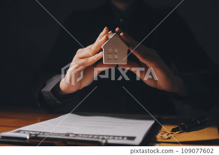 Real estate agent and customer signing contract to buy house, insurance or loan real estate.rent a house,get insurance or loan real estate or property. 109077602