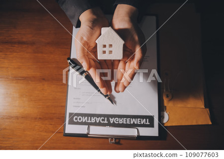 Real estate agent and customer signing contract to buy house, insurance or loan real estate.rent a house,get insurance or loan real estate or property. Real estate agent and customer signing contract to buy house, insurance or loan real estate.rent a house,get insurance or loan real estate or property. 109077603