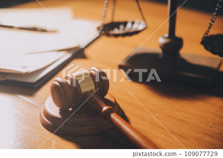 law books and scales of justice on desk in library of law firm. jurisprudence legal education concept. 109077729