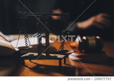 law books and scales of justice on desk in library of law firm. jurisprudence legal education concept. law books and scales of justice on desk in library of law firm. jurisprudence legal education concept. 109077787