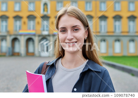 Young girl student posing outdoors, background of educational building 109078740