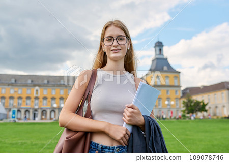 Young girl student posing outdoors, background of educational building 109078746