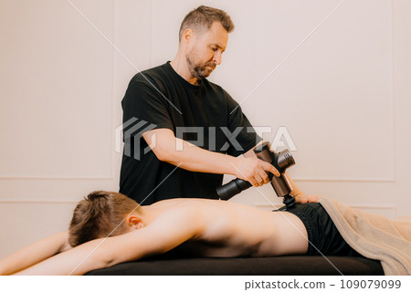 Man professional doctor osteopath fixing and stretching mans back with hands during exersicing at rehabilitation theapy in manual therapy clinic, top view. Chiropractor during work 109079099