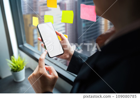 Business woman hand holding using mockup mobile phone with white blank screen for text, mobile app design and advertising, online marketing 109080785