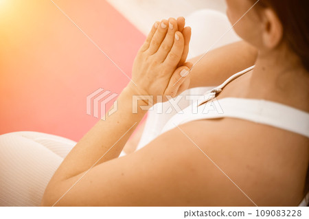 Girl does yoga. Young woman practices asanas on a beige one-ton background. Girl does yoga. Young woman practices asanas on a beige one-ton background. 109083228