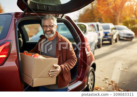 Donation concept - male holds a box of donations 109083311