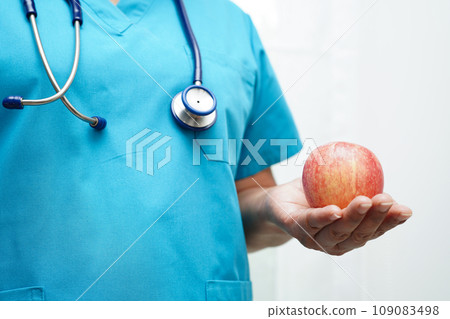 Asian Nutritionist holding apple healthy food for patient in hospital, nutrition and vitamin. Asian Nutritionist holding apple healthy food for patient in hospital, nutrition and vitamin. 109083498