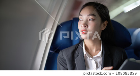 Successful Asian business woman, Business woman working in airplane cabin during flight on tablet 109083859