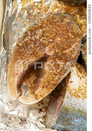 raw yellow-tailed fish during cutting for cooking 109084682