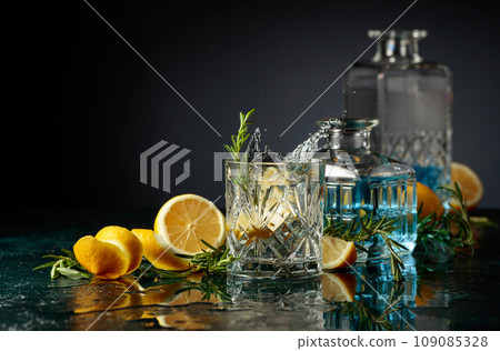 Gin tonic cocktail with lemon and rosemary. Gin tonic cocktail with lemon and rosemary. 109085328