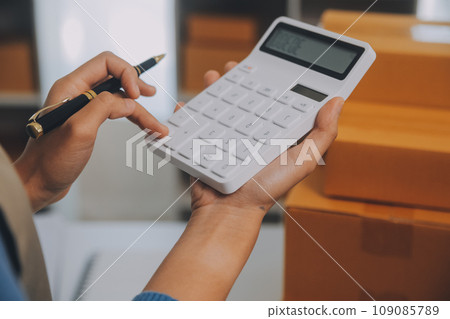 Business woman start up small business entrepreneur SME success .freelance woman working at home with Online Parcel delivery. SME and packaging deliveryconcept 109085789