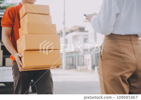 Asian Woman Receiving Product from delivery man at Home, Young Owner Woman Order Product from Smartphone Application, Woman with Online Business or SME Concept. 109085867