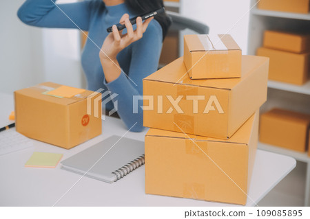 Business woman start up small business entrepreneur SME success .freelance woman working at home with Online Parcel delivery. SME and packaging deliveryconcept 109085895