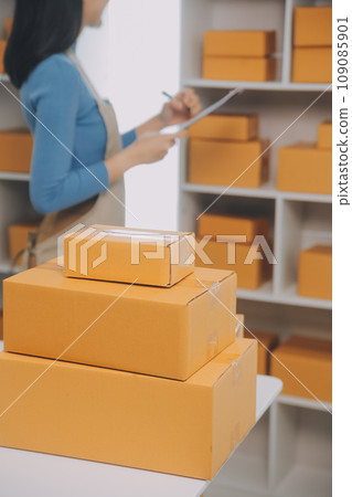 Business woman start up small business entrepreneur SME success .freelance woman working at home with Online Parcel delivery. SME and packaging deliveryconcept 109085901