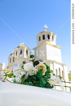 A rose-decorated wedding car against the backdrop of a church's glittering gilded domes. Vertical orientation. Selective focus. 109086424
