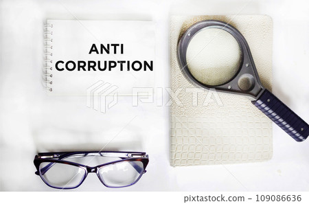 Anti-corruption phrase written on a notepad and white background. Anti-corruption phrase written on a notepad and white background. 109086636