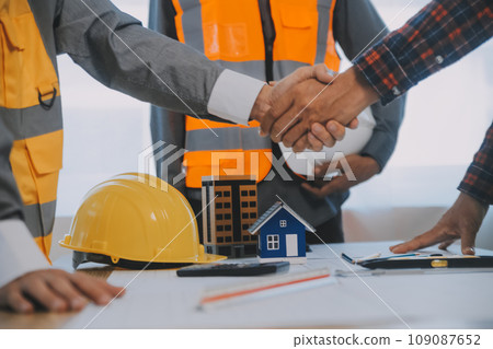 Construction and structure concept of Engineer or architect meeting for project working with partner and engineering tools on model building and blueprint in working site, contract for both companies. Construction and structure concept of Engineer or architect meeting for project working with partner and engineering tools on model building and blueprint in working site, contract for both companies. 109087652