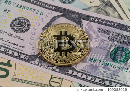 Golden bitcoin coin on a paper dollars money Golden bitcoin coin on a paper dollars money 109088016