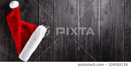 Santa Claus hat on wooden rustic background. Christmas and new year celebration Santa Claus hat on wooden rustic background. Christmas and new year celebration 109088136