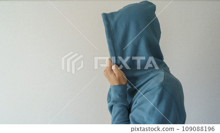Person wearing a hoodie, suspicious person image 109088196