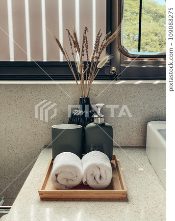 Two hand towels in the bathroom with liquid soap dispenser on bamboo tray Two hand towels in the bathroom with liquid soap dispenser on bamboo tray 109088275