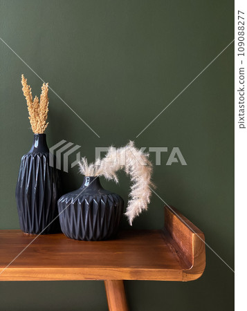 Two black vases with dried grass and plants 109088277